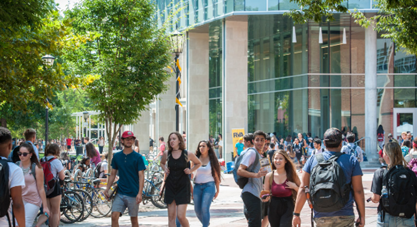 Students walking through campus near the library